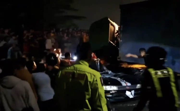 Petugas kepolisian dibantu warga evakuasi korban tertimpa truk kontainer di Jalan Bendasari Karawang Timur/Foto: Istimewa