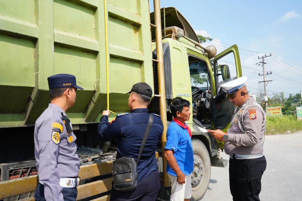 Petugas Ditlantas Polda Riau dan BPTD memeriksa truk overdimension dan overload dalam Operasi Keselamatan Lancang Kuning 2026 di Jalan Riau Ujung