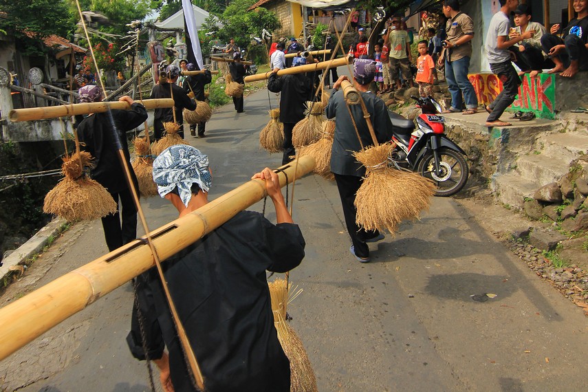 Para pemain kesenian rengkong mengenakan pakaian adat Kasepuhan Sunda saat mengarak hasil bumi dalam upacara Seren Taun