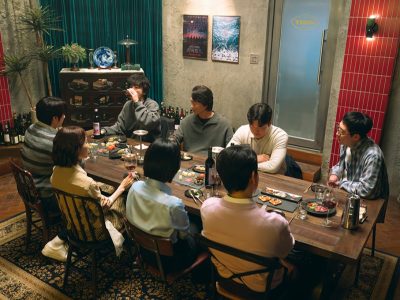 Para pemeran pendukung drama We Are All Trying Here yang terdiri dari delapan anggota kelompok sineas di restoran Ajit tempat mereka berkumpul