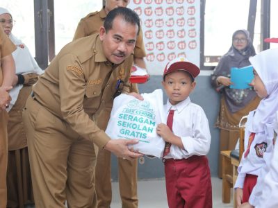Sekda Siak Mahadar menyerahkan bantuan seragam sekolah gratis kepada siswa baru di SD Negeri 14 Teluk Mesjid/Foto: Media Center Siak